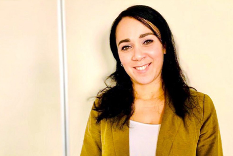 2 Amel Zennir souriante sur fond orange pour parler de l'accompagnement des entreprise dans leurs démarches DSN