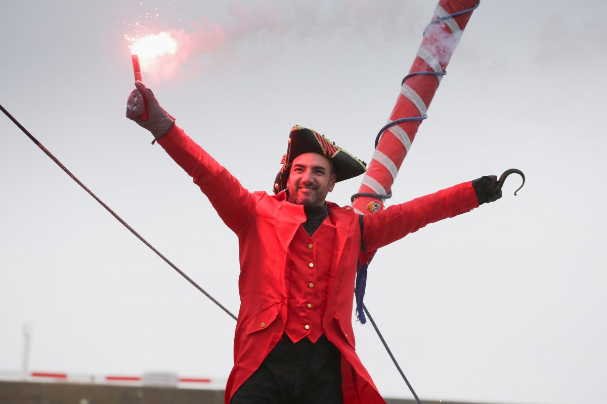 2 Damien Seguin skipper au Vendée Globe sur la ligne d'arrivée déguisée en pirate avec son crochet en remplacement de sa main gauche et un fumigène dans l'autre main.