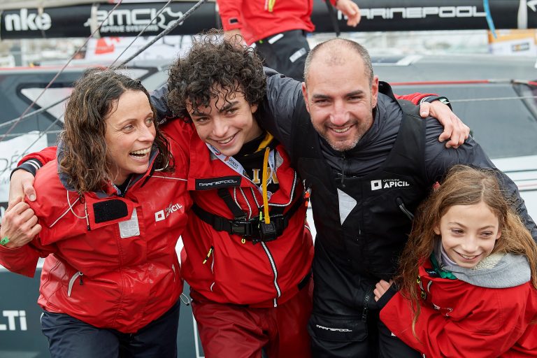 Photographie de Damien Seguin avec sa femmes et ses enfants devant son bateau à son retour du Vendée Globe
