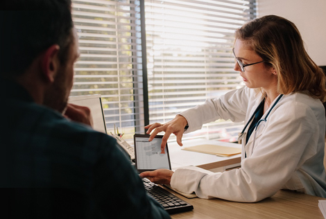 2 Une femme médecin explique à un patient homme ce que le coût d'hospitalisation va lui coûter et l'offre MBTP HOSPIT proposé par la MBTP