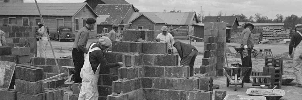 Photographie en noir et blanc d'ouvrier maçon sur une chantier de construction dans les années 80
